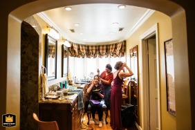 At a residence in Saratoga, California, the bride prepares for her wedding day, framed gracefully under an arched doorway and photographed from an adjoining room, emphasizing the intimacy and quiet beauty of her getting ready experience.